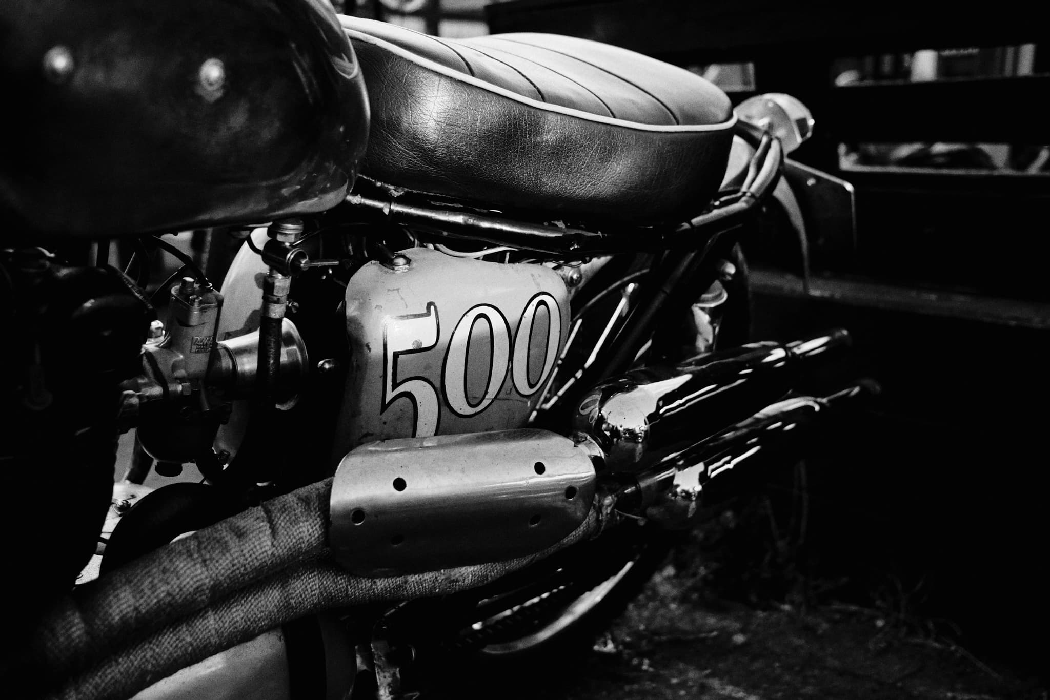 Monochrome close-up of a vintage motorcycle engine and seat